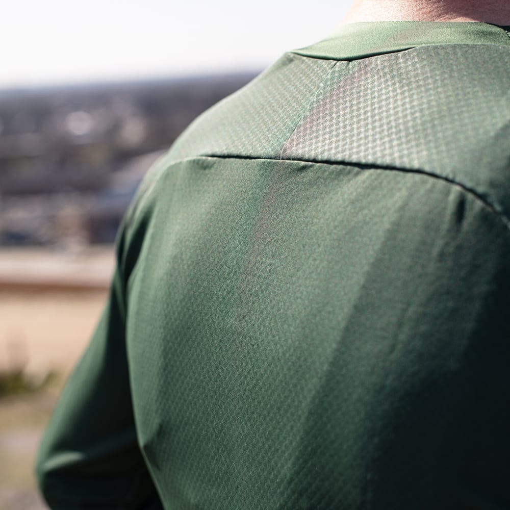Close-up of the back panel of the Off-Road Long Sleeve Shirt Green, showcasing the breathable mesh fabric and technical texture.
