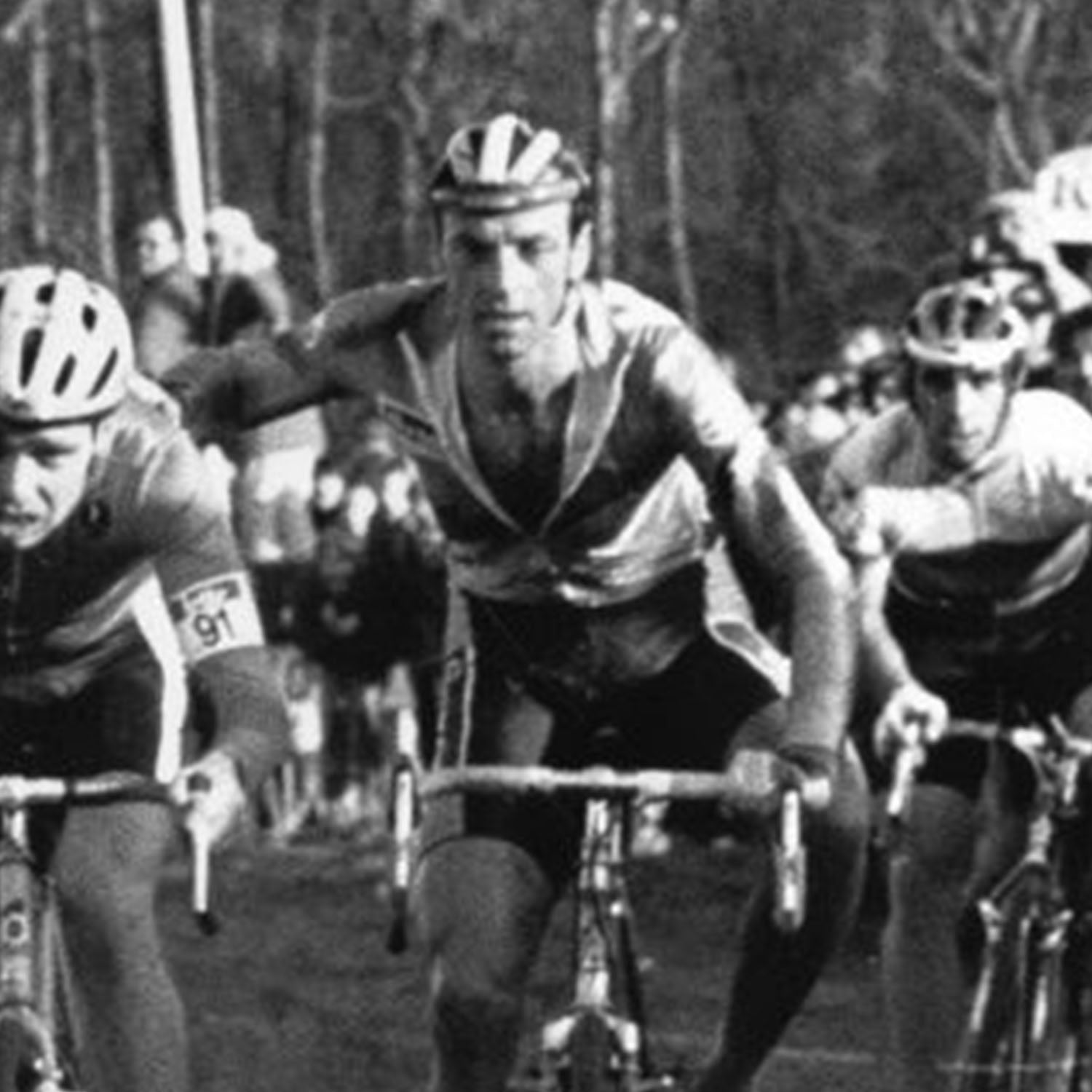 Black and white photo of Paul Herygers racing through the mud during a cyclocross event, representing the first Bioracer World Champion.