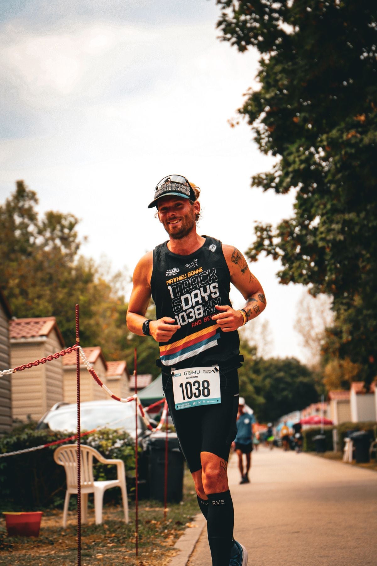 Matthieu Bonne running during his 6-day ultrarun challenge, wearing a black race tank with "Track 6 Days 1038KM.