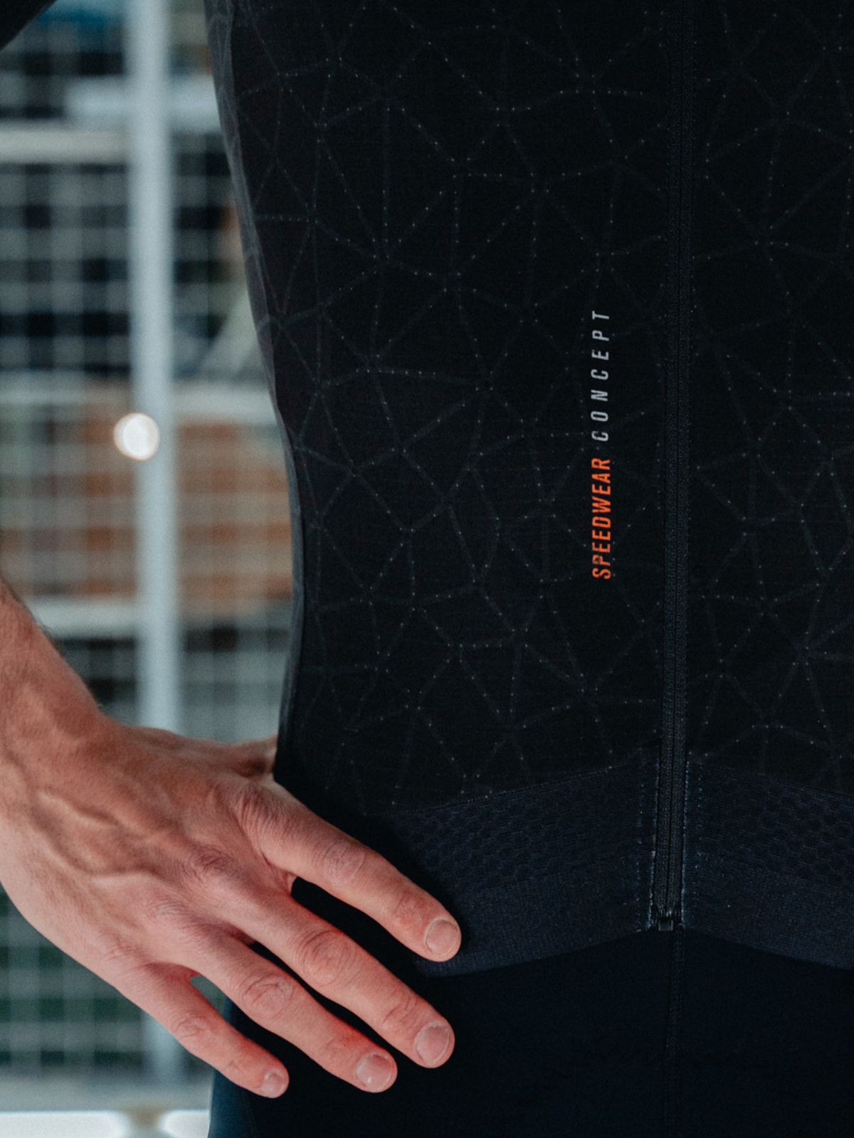 Close-up of Bioracer Speedwear Graphene black jersey showing mesh powerband and geometric texture details
