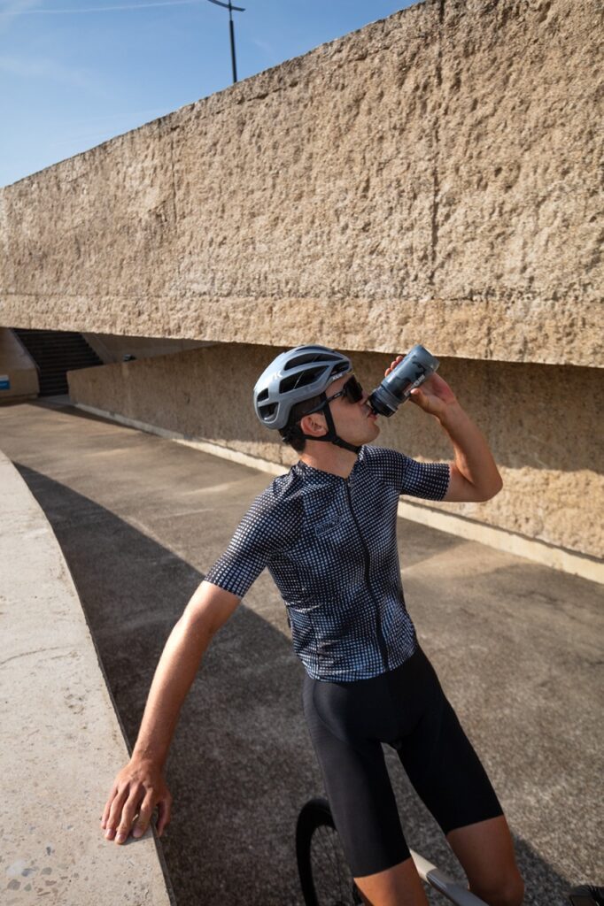 cyclist taking a sip from his bidon, wearing cycling apparel from bioracer